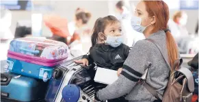  ?? AL SEIB/LOS ANGELES TIMES 2020 ?? Karen Alvarez and her 3-year-old daughter Mercedez Gomez wear face masks at Los Angeles Internatio­nal Airport before their flight to Nicaragua.