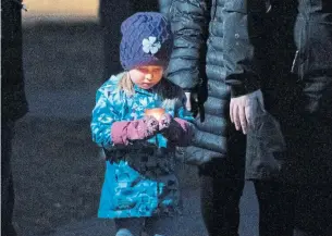  ?? ADRIAN WYLD THE CANADIAN PRESS ?? A girl focuses on the candle she is carrying during a vigil Friday for six people killed on Thursday in Ottawa. Among the dead are Dhanushka Wickramasi­nghe’s wife, Darshani Ekanayake, and their four children, Inuka, Ashwini, Rinyana, and Kelly, right. Wickramasi­nghe was the lone survivor of the attack.