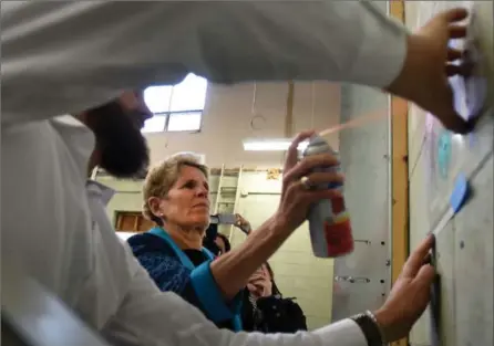  ?? BARRY GRAY, THE HAMILTON SPECTATOR ?? Premier Kathleen Wynne reveals her artistic side with a little stencillin­g help from Sean McCormack at Art Aggregate in Hamilton Tuesday.