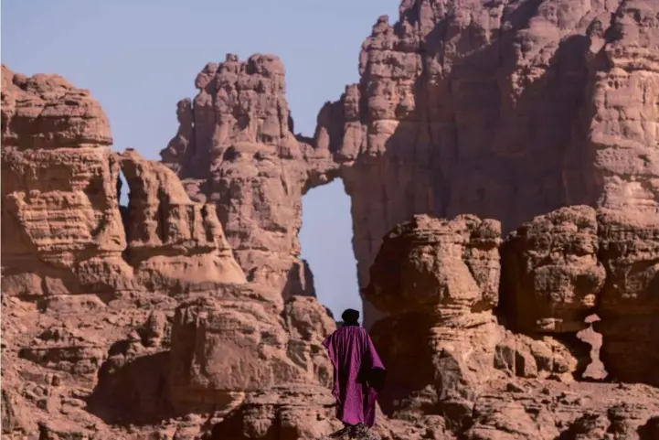  ?? MATJAZ KRIVIC ?? Abdullah, a guide in Algeria’s Tassili n’Ajjer National Park, looks toward “The Cathedral,” a towering naturally occurring sandstone structure.