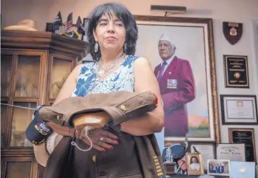  ?? ROBERTO E. ROSALES/JOURNAL ?? Mona Lisa Rodriguez stands in front of a portrait of her father, Ralph Rodriguez Jr., in his Albuquerqu­e home on Thursday. Rodriguez, a survivor of the Bataan Death March, died Saturday at 100.