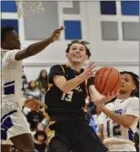  ?? KYLE FRANKO — TRENTONIAN PHOTO ?? Nottingham’s Joe Lemly, center, lays the ball in the basket between Ewing’s Cameron James, left, and Grady Griffin, right, during the Central Group III championsh­ip boys basketball game at Emil Wandishin Gym.