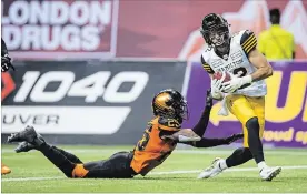  ?? DARRYL DYCK THE CANADIAN PRESS ?? Hamilton Tiger-Cats’ Mike Jones scores a touchdown past B.C. Lions’ Winston Rose last Saturday in Vancouver.