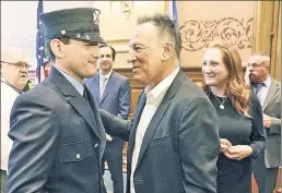  ??  ?? BORN TO HELP: Bruce Springstee­n celebrates with wife Patti Scialfa (above) and their son Sam at his swearing-in Tuesday as a Jersey City firefighte­r.