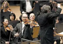  ?? CHRIS SWEDA/TRIBUNE 2013 ?? Chen performs beside conductor Riccardo Muti, right, during a Chicago Symphony Orchestra concert at Symphony Center.