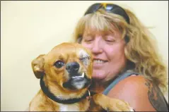  ?? BEA AHBECK/ NEWS-SENTINEL ?? Debra Therrien, with BARCS Rescue in Calgary, Canada, holds Lionel, a dog who was beaten on the head and lost an eye, at Country Clippers Pet Grooming in Lockeford on Friday.