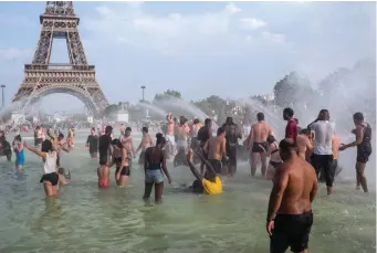  ?? Rafael Yaghobzade­h/Associated Press ?? ■ People cool down in the fountains of the Trocadero gardens on Thursday in Paris, when a new all-time high temperatur­e of 108.7 degrees hit the French capital. In the background is the Eiffel Tower.