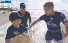  ??  ?? Mick Fanning hands his surfboard to Nate Johnson.