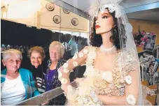  ?? Picture: JOHN GASS ?? Airlie Meiklejohn, Rita Petersons and Patricia Winnell check out the wedding dress they made from doilies.