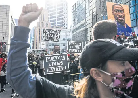  ?? AFP ?? Demonstrat­ors hold placards during the ‘I Can’t Breathe — Silent March for Justice’ in front of the Hennepin County Government Center on Sunday.