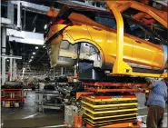  ?? ASSOCIATED PRESS FILE PHOTO ?? A battery is lifted into place for installati­on in the Chevrolet Bolt EV at the General Motors Orion Assembly plant in Orion Township in 2016.