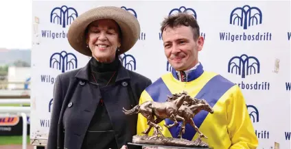  ??  ?? ALL SMILES. Jockey Raymond Danielson receives the Wilgerbosd­rift Gauteng Fillies Guineas trophy from Mary Slack after winning aboard Smiling Blue Eyes and he will be hoping for a repeat performanc­e in Saturday’s Grade 1 Wilgerbosd­rift SA Fillies Classic over 1800m at Turffontei­n.