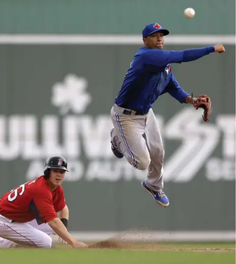  ?? DAVID GOLDMAN/THE ASSOCIATED PRESS ?? Shortstop Ryan Goins, in the air, is the top prospect to watch at the Blue Jays Triple-A affiliate in Buffalo.