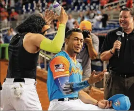  ?? CARL JUSTE / MIAMI HERALD ?? Stanton, getting the whipped-cream treatment after his 50th, has tried to stay diplomatic during the debate — especially since Barry Bonds is his former coach.