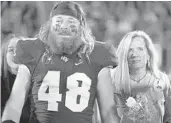  ?? PHELAN M. EBENHACK/AP ?? UCF punter Mac Loudermilk, left, plans to cut his iconic flowing hair, donating it to Locks of Love. He’s also raising money for the charity.