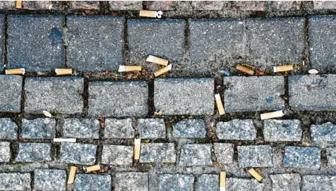  ?? Foto: Jens Kalaene, dpa (Symbolbild) ?? Auf den Boden geworfene Zigaretten­stummel sind in vielen Orten ein Ärgernis.