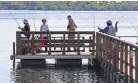  ?? MICHAEL SEARS / MILWAUKEE JOURNAL SENTINEL ?? People fish from the pier at Lakefront Park in Pewaukee on Wednesday.