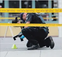  ?? RICHARD LAUTENS TORONTO STAR ?? Officers examine a shell casing. Three people have died including the gunman in a mass shooting on The Danforth in Toronto Sunday night.