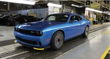  ?? PETER BLEAKNEY ?? A 707-hp Dodge Challenger Hellcat rolls off the line. It once was part of a roll of steel. Those rear tires have no idea what they’re in for.