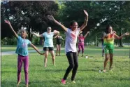  ?? MEDIANEWS GROUP FILE PHOTO ?? Girls and women wave their hands in the air during an outdoor Zumba fitness class at Memorial Park in Pottstown.