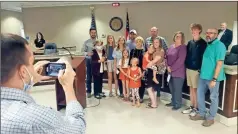  ?? Jeremy stewart ?? Polk County Assistant Manager Connor Hooper (left) takes a photo of retiring County Clerk Dawn Turner and her family, who surprised her by attending April county commission meeting Tuesday, April 6, 2021.