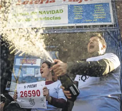  ?? PAU VENTEO / EUROPA PRESS ?? Dos loteros celebran que el primer premio ha sido vendido en su establecim­iento, en Barcelona.