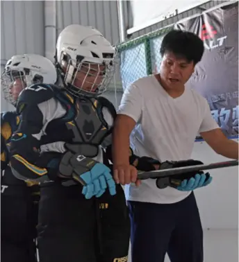  ??  ?? A coach (right) trains an ice hockey player in Shicheng, a county in Jiangxi Province, east China, on July 17