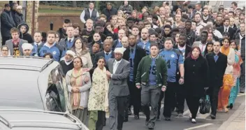  ?? ?? Hundreds of mourners gather to form part of the funeral convoy.