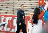  ?? LUIS SÁNCHEZ SATURNO/THE NEW MEXICAN ?? UNM athletic director Eddie Nuñez refused to go on the record with a formal statement about coach Bob Davie’s tenure while watching Friday’s first half from the sidelines at Dreamstyle Stadium.