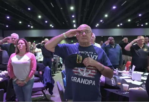  ?? Ed Zirkle ?? Veterans stand at attention during the national anthem at a Veterans Breakfast Club event at Rivers Casino on the North Shore in November 2023.