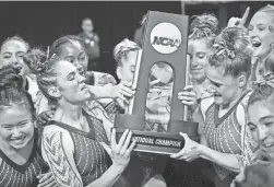  ?? J ?? The Oklahoma team celebrates with the trophy after clinching first place during the finals of the 2022 NCAA women’s gymnastics championsh­ip on Saturday at Dickies Arena in Fort Worth, Texas.