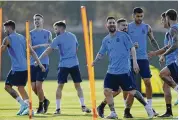  ?? JORGE SAENZ / AP ?? Argentina’s Lionel Messi (right) smiles Monday during a training session for today’s Group C World Cup soccer match against Saudi Arabia.