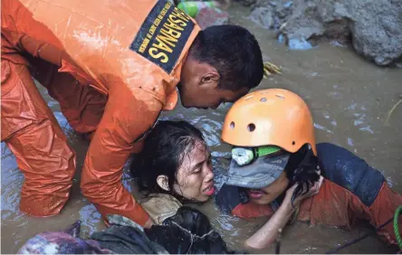  ??  ?? Indonesian rescuers try to free a 15-year-old earthquake survivor, Nurul Istikharah, from the flooded ruins of a collapsed house in Palu, Indonesia, on Sunday. Her mother was among those residents who died.