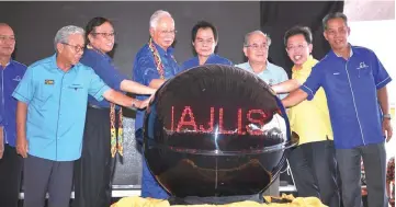  ?? — Bernama photo ?? Najib (fifth right) and other VIPs putting their hands on the digital globe to symbolical­ly launch the ‘meet the people’ gathering and groundbrea­king ceremony for the constructi­on of Marudi bridge.