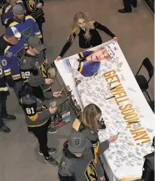  ?? Ethan Miller / Getty Images ?? Fans in Las Vegas sign a banner for Jay Bouwmeeste­r before the Blues and Golden Knights played Thursday.