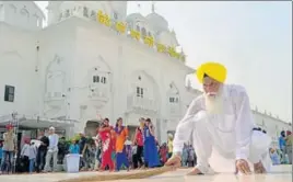  ?? SAMEER SEHGAL /HT ?? Gurdwara Chhota Ghallughar­a chief Johar Singh performing sewa outside the Golden Temple in Amritsar on Sunday.