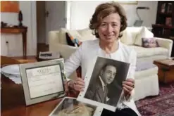  ??  ?? Lauren Friedman, daughter of lawyer Samuel Friedman, poses with photos of her father, and a telegram from Thurgood Marshall, in her New York apartment. — AP photos