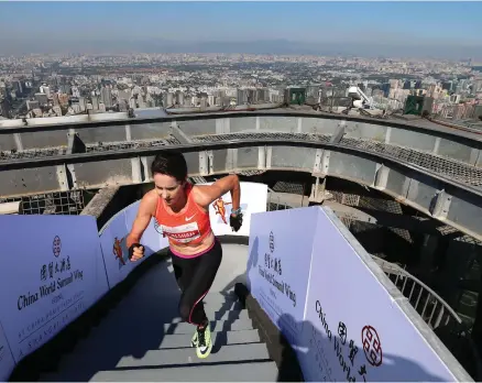  ??  ?? Suzy Walsham runs up the last of 2,041 steps of the China World Summit Wing Hotel Vertical Run in Beijing, in September, 2016. She scaled the 82 floors, to a height of 330 metres, in 11 minutes and 51 seconds to win the event EPA