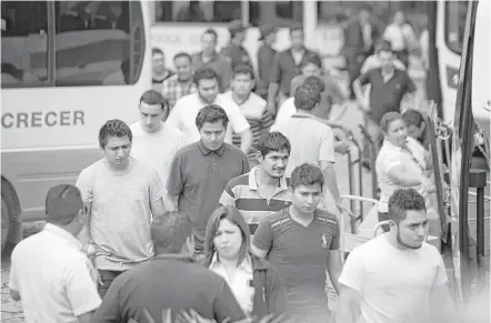  ?? Marie D. De Jesús photos / Houston Chronicle ?? Salvadoran deportees walk away from buses toward the government’s migrant assistance center in San Salvador, where they are provided help with orientatio­n, fresh clothing and the opportunit­y to call their families to pick them up.