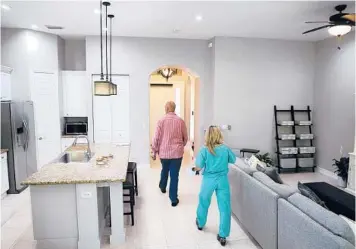  ?? CARLINE JEAN/SUN SENTINEL ?? A potential buyer views a home with her Realtor during an open house in Parkland, Florida.