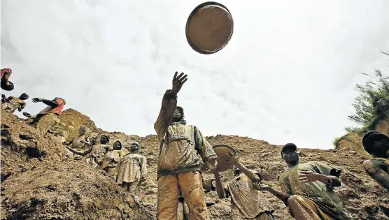  ?? Picture: REUTERS ?? SLINGING MATCH: Gold miners form a human chain, passing pans of mud at Chudja mine, northeast DRC. Local conflict is driven by the struggle for the country’s vast resources