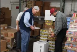  ?? The Sentinel-Record/Grace Brown ?? FRESH DELIVERY: Volunteers with Project HOPE Food Bank, Charles Hood, left, and Gordon Hager unload a fresh shipment of canned goods at the food bank on Monday.