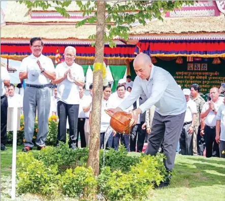  ?? NATIONAL ASSEMBLY VIA FACEBOOK ?? King Norodom Sihamoni waters a tree on Tuesday at a ceremony marking National Tree Planting Day in Kratie province.