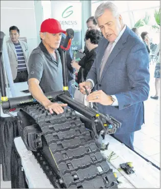  ?? KENN OLIVER/THE TELEGRAM ?? Premier Dwight Ball chats with Jim Maidment, president of Roshell Industries and inventor of the Skizee Woodsrunne­r, a motorized device that propels skiers across and through snow. The company, based in Happy ValleyGoos­e Bay, is client of the Genesis...