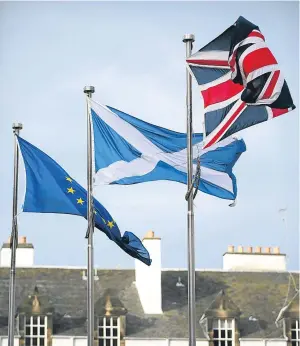  ??  ?? EU, Saltire and Union flags wave above the Scottish Parliament.