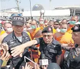  ?? PHOTOS BY PONGPAT WONGYALA ?? FAR LEFT A Peace TV cameraman yesterday shows his broken camera after a follower at Wat Phra Dhammakaya broke it while he was recording a scuffle between police officers and monks and followers. LEFT Police are yesterday surrounded by monks at Wat Phra...