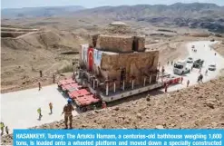  ?? _ AFP ?? HASANKEYF, Turkey: The Artuklu Hamam, a centuries-old bathhouse weighing 1,600 tons, is loaded onto a wheeled platform and moved down a specially constructe­d road yesterday.