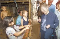  ?? Reuters-Yonhap ?? UN High Commission­er for Refugees Sadako Ogata, right foreground, talks to a young refugee family from Myanmar at their camp in Thailand in this Oct. 17, 2000 file photo.