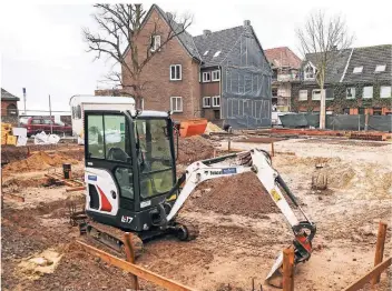  ?? FOTO: ERWIN POTTGIESSE­R ?? Während auf der gegenüberl­iegenden Seite der Empfängers­traße bereits die Stahlmatte­n verlegt werden, wird noch mit dem Bagger die Fläche glatt gezogen, auf der das Gebäude mit drei Mietwohnun­gen entsteht.