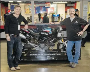  ?? MARISSA BAECKER — SPECIAL TO THE SUN ?? Scott Bentley ( left) and Dave Groleau of Bentley Motorrad in Kelowna stand with the Ducati Monster 696 Kelowna Rockets fan bike. Fans can enter to win the motorcycle by purchasing a raffle bracelet with proceeds being donated to the Canadian Cancer...